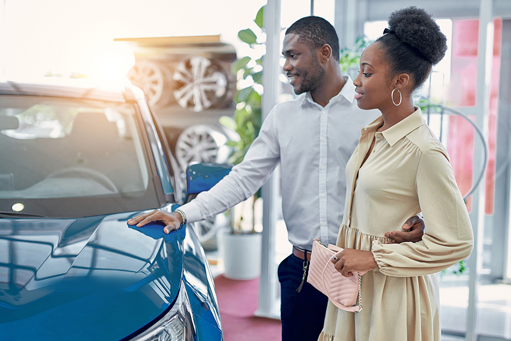 couple shopping for electric vehicle at dealership